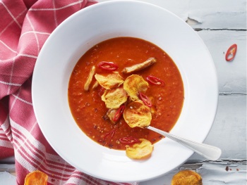 Kruidige paprikasoep met zoete aardappelchips en kip piri piri product foto
